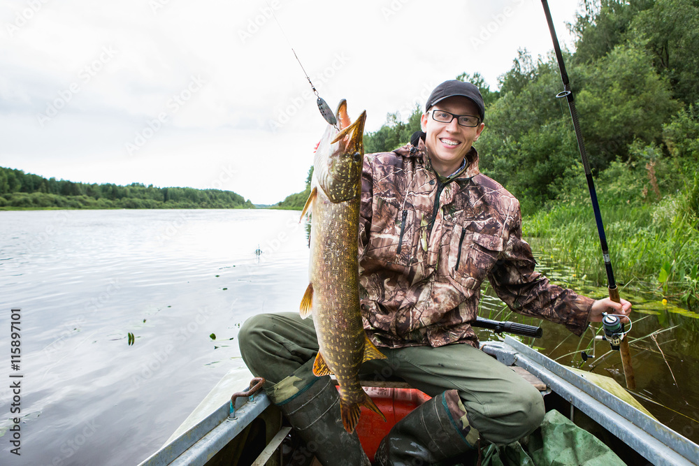 man caught a big pike, fishing Spinning, a fisherman in a boat man caught a big pike, fishing Spinning, a fisherman in a boat