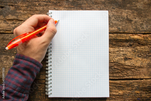 left-handed man writes in a notebook photo