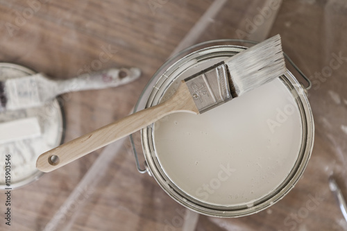 Paint brush resting on paint tin viewed from above