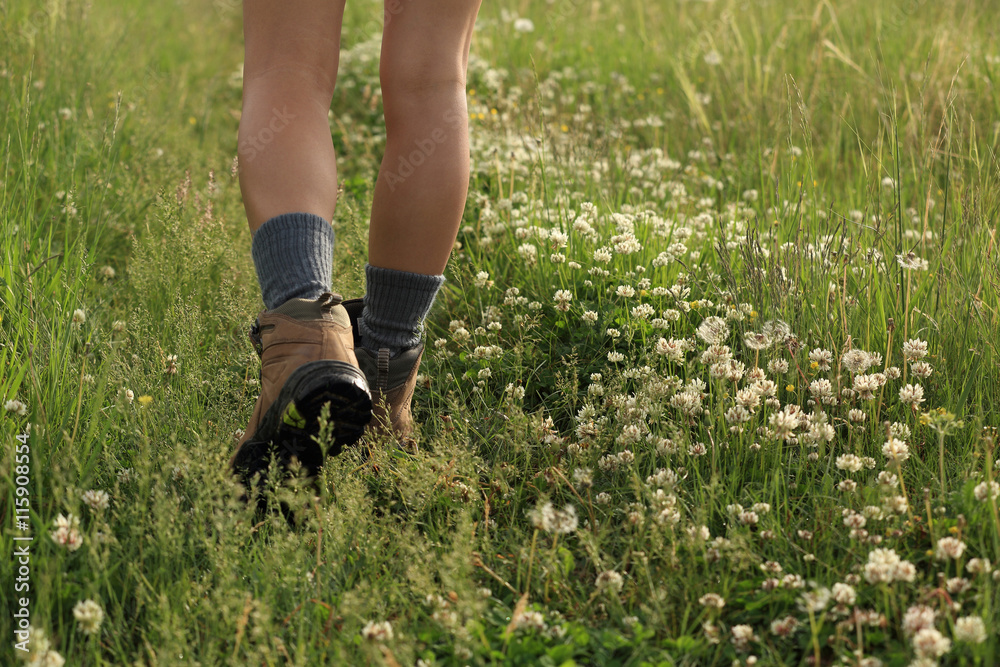 young woman hiker legs walking on trail in grassland young woman hiker legs walking on trail in grassland