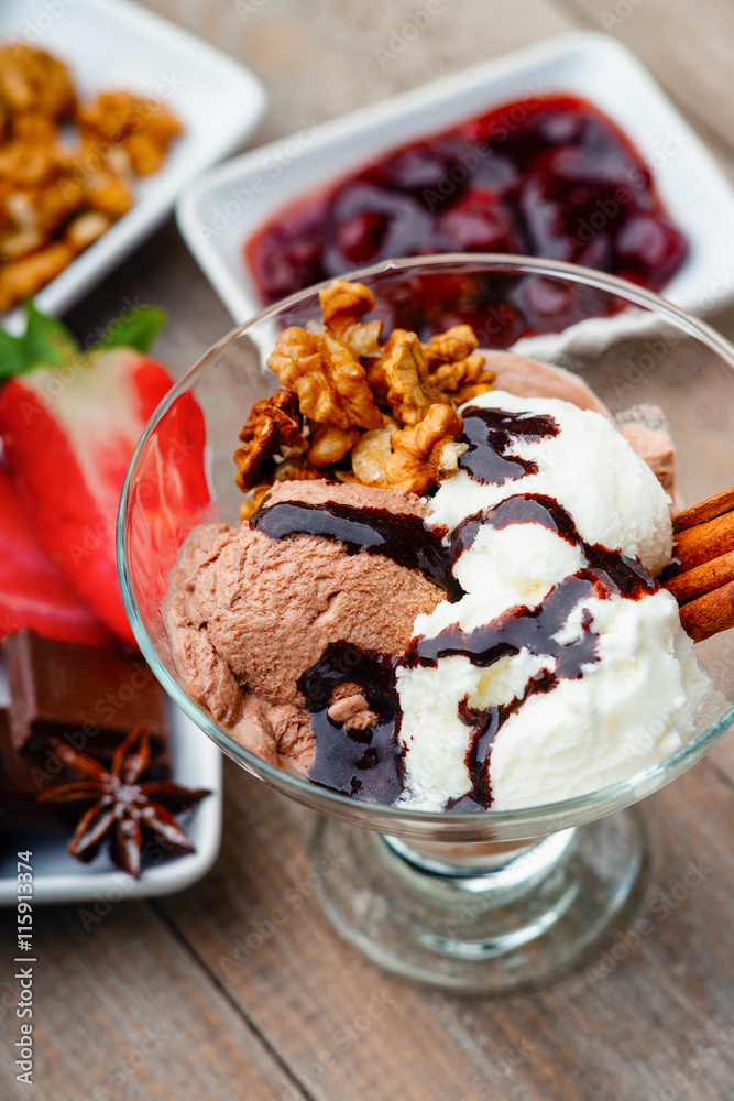 Ice cream sundae, chocolate, walnuts and sliced strawberry Ice cream sundae, chocolate, walnuts and sliced strawberry