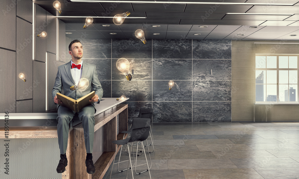 Businessman reading old book . Mixed media Businessman reading old book . Mixed media