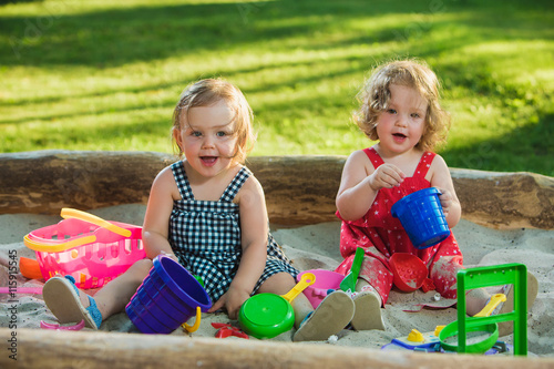 Photography The two little baby girls playing toys in sand