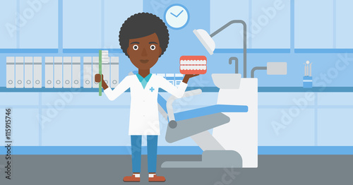 Dentist with dental jaw model and toothbrush.