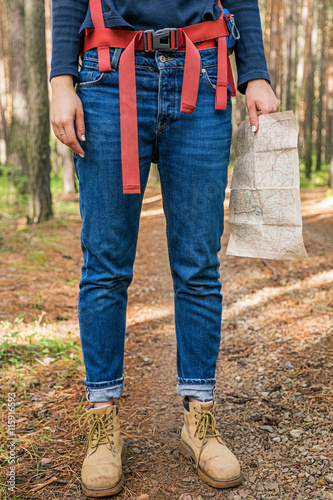 Female backpacker with map in forest