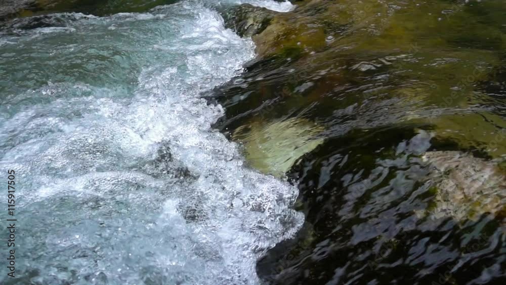 SLOW MOTION: flowing water over stones in mountines river SLOW MOTION: flowing water over stones in mountines river