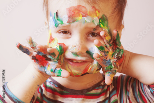 Happy cute little girl with colorful painted hands