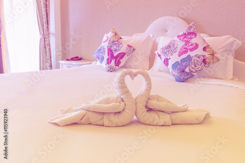 Pink bedroom with folded towel in swan shape on bed prepare for lover in resort ,Thailand