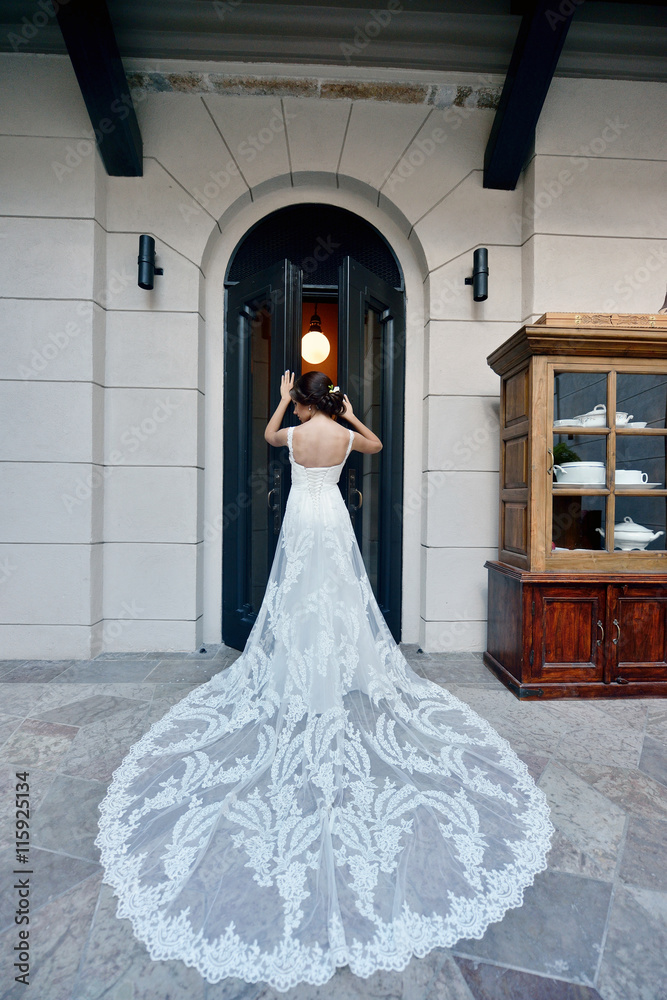 Beauty bride in lace bridal gown indoors. Beautiful model girl in a white wedding dress. Female portrait of cute lady. Woman with hairstyle Beauty bride in lace bridal gown indoors. Beautiful model girl in a white wedding dress. Female portrait of cute lady. Woman with hairstyle