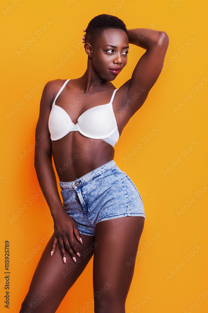 Beautiful african girl wearing jeans shorts and bra while posing
