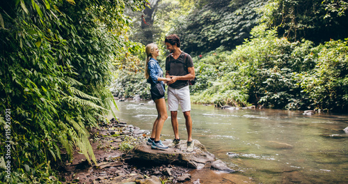 Loving young couple standing by mountain stream