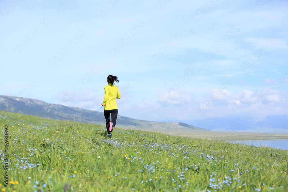 healthy young woman trail runner running on beautiful mountain trail