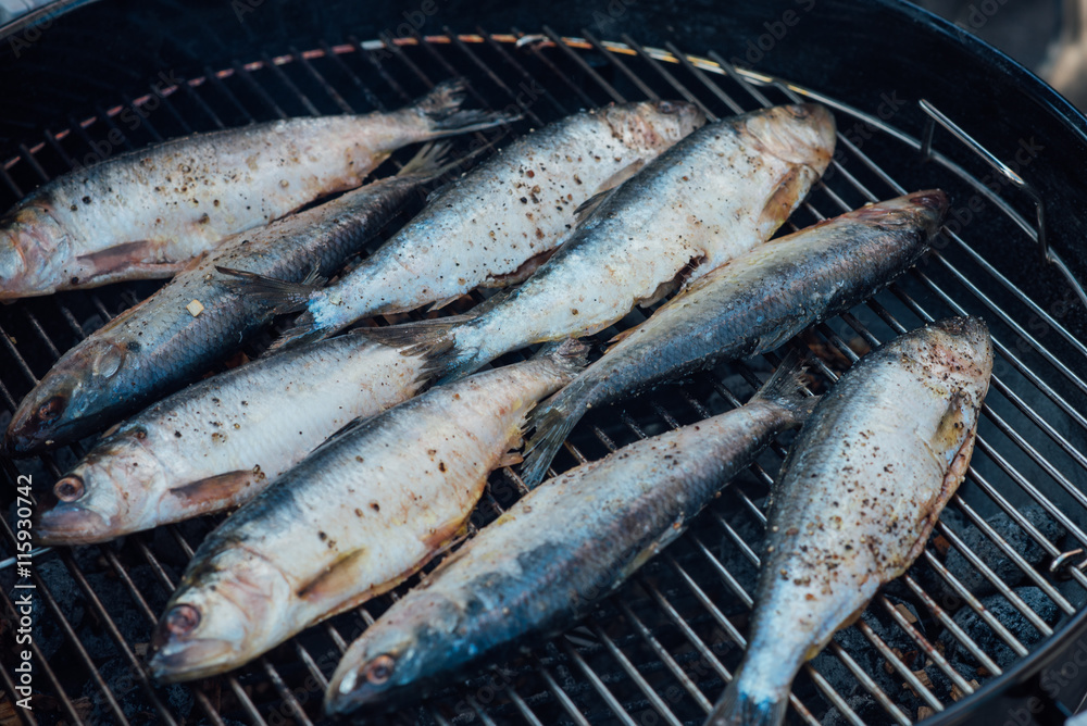 Fresh small fish - mullet and smelt - marinated with salt and pepper fried on grill Fresh small fish - mullet and smelt - marinated with salt and pepper fried on grill