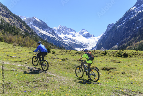 Vater und Sohn beim Mountainbiken vor schöner Bergkulisse