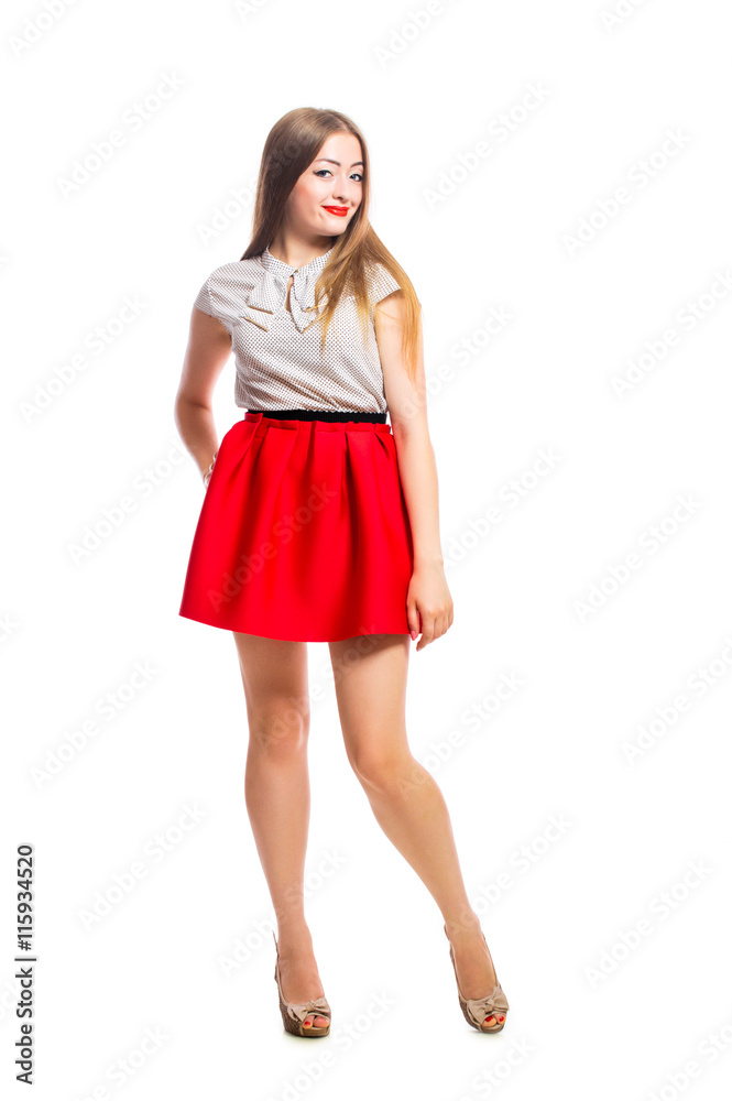 Young beautiful smiling woman in a red skirt posing in studio isolated on white background. Young beautiful smiling woman in a red skirt posing in studio isolated on white background.