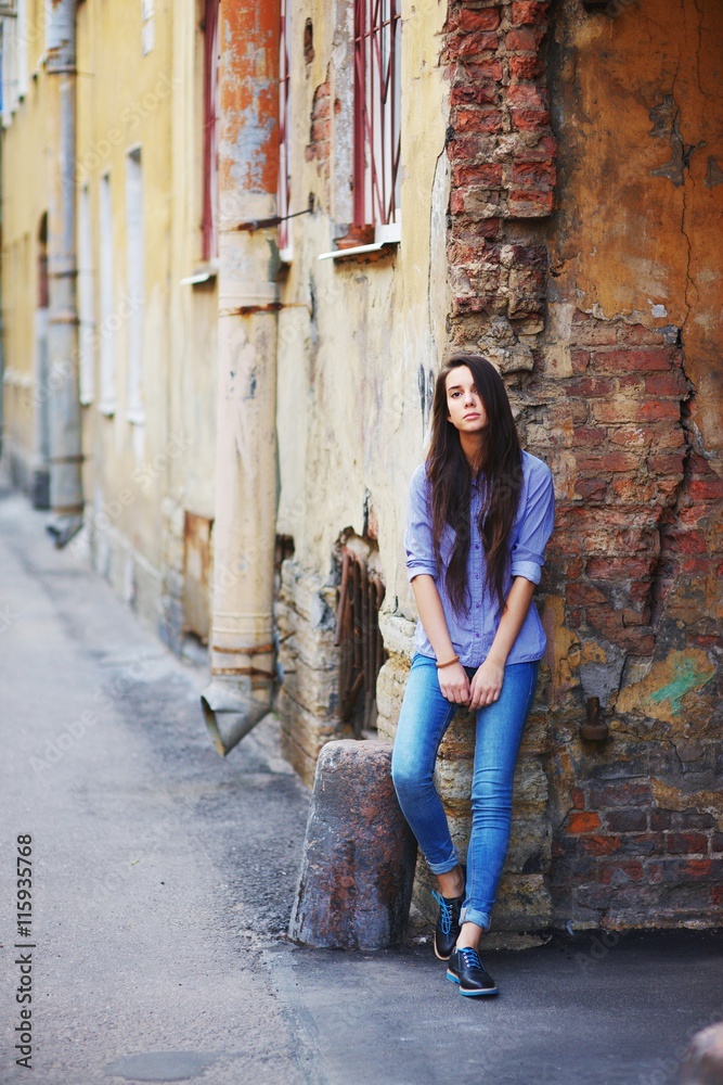 Beautiful brown eyed girl with long hair in jeans and a striped