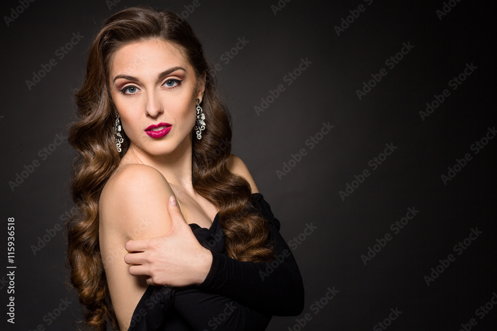 Portrait of serious beautiful model woman with red lips posing in studio. Lady in black dress showing her gorgeous shoulders over black background. Portrait of serious beautiful model woman with red lips posing in studio. Lady in black dress showing her gorgeous shoulders over black background.