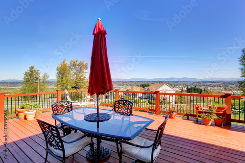 Wooden walkout deck with patio table overlooking beautiful landscape