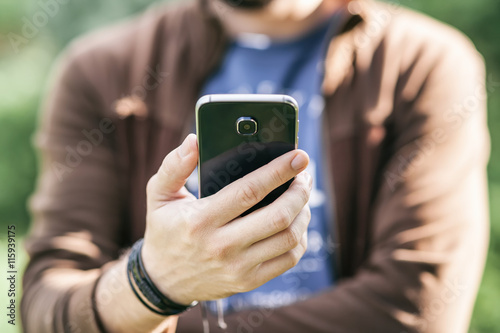 Man's hand holding mobile smartphone, young businessman at work