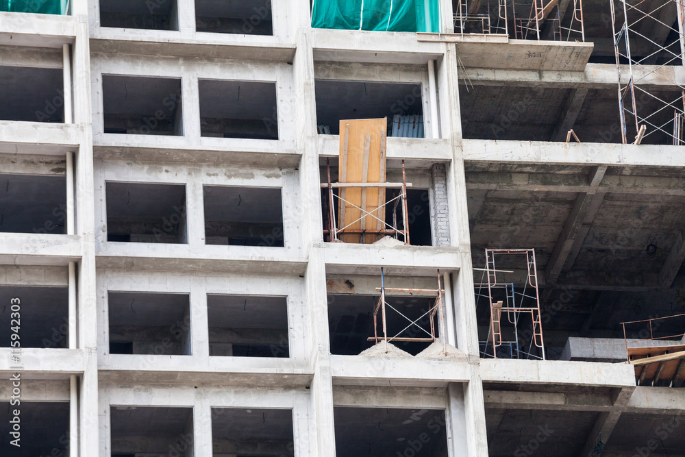 Construction site view of crane, lift, metal beam, brick, metal ladder and concrete