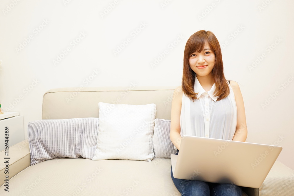 Young japanese woman using a computer on the sofa ソファーでリラックスしてパソコンを使う若い日本人の女性 Young japanese woman using a computer on the sofa ソファーでリラックスしてパソコンを使う若い日本人の女性