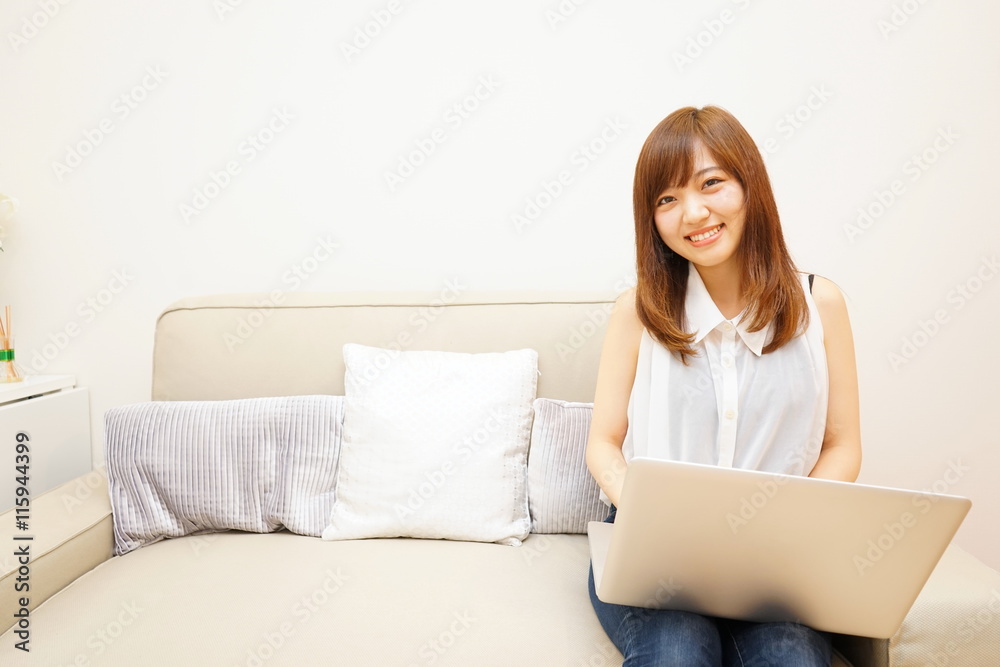 Young japanese woman using a computer on the sofa ソファーでリラックスしてパソコンを使う若い日本人の女性 Young japanese woman using a computer on the sofa ソファーでリラックスしてパソコンを使う若い日本人の女性