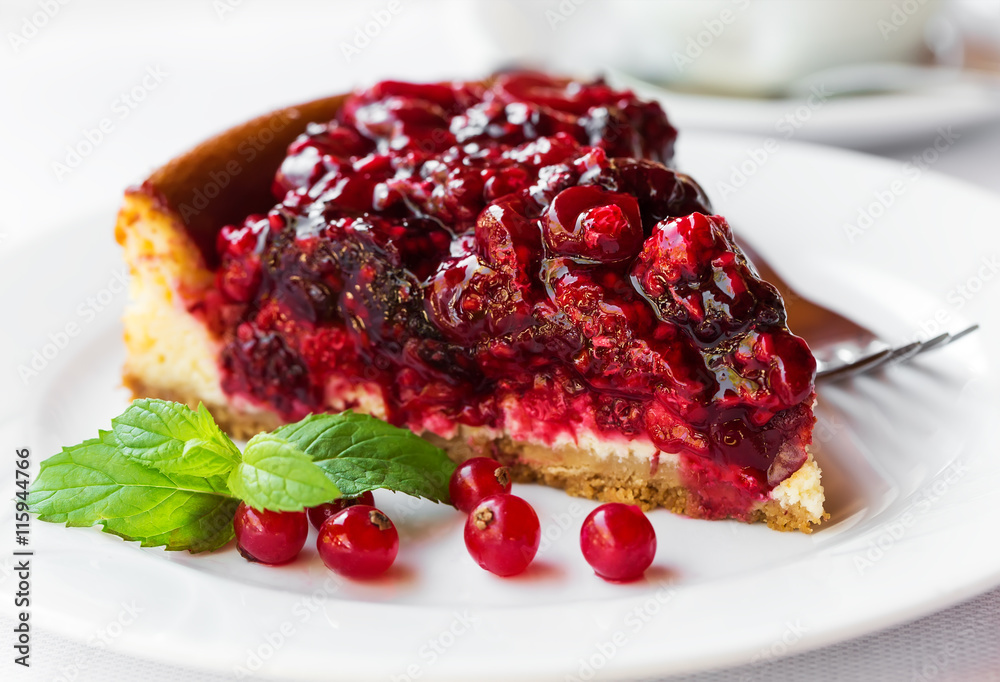 Wild berries cake with green mint on plate with fork Wild berries cake with green mint on plate with fork