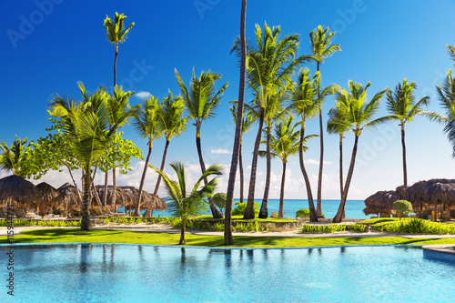 Foto Tropical beach resort with lounge chairs and umbrellas
