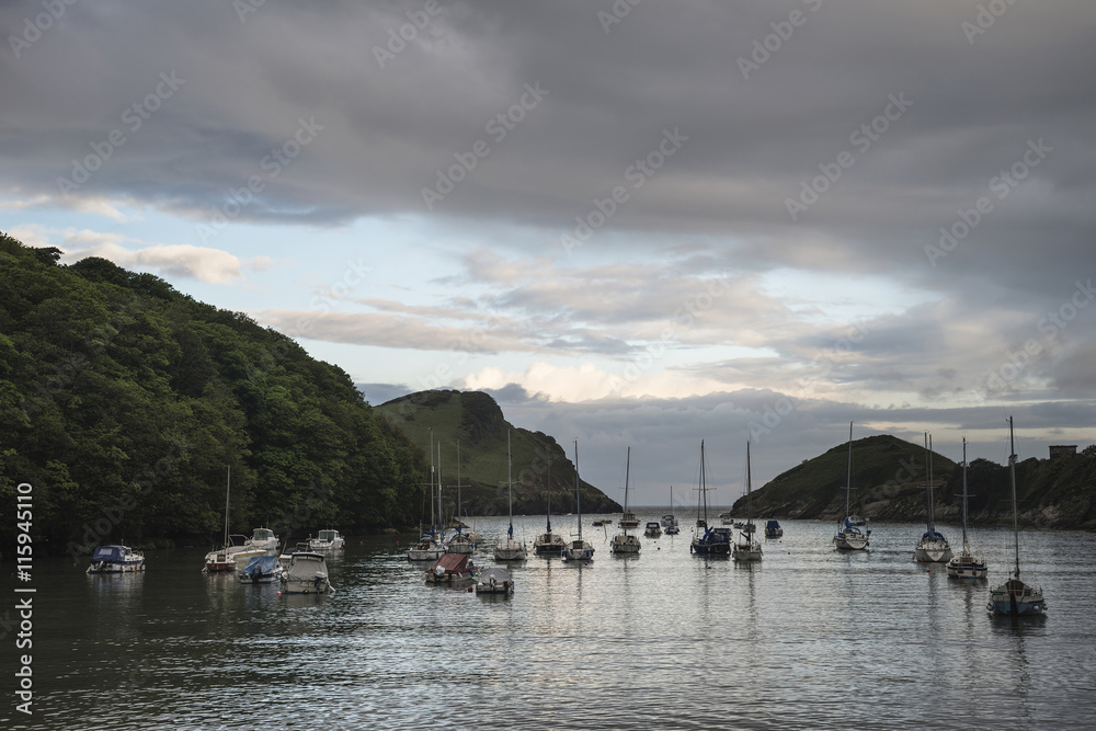 Landscape image of boats moored in harbour in Devon at sunrise