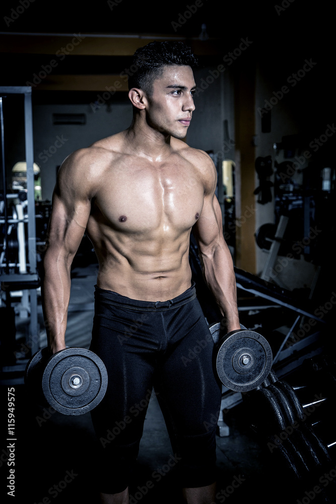 Young man exercising in dark and old gym Young man exercising in dark and old gym