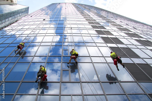 Group of workers cleaning windows service of modern office build