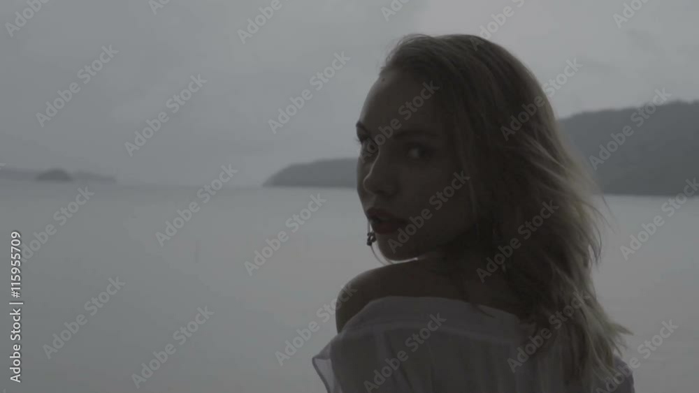 Closeup portrait of pretty naturally looking woman on summer day wearing boho white shirt and earrings shaking hair on a terrace over beautiful sea landscape background - video in slow motion. Closeup portrait of pretty naturally looking woman on summer day wearing boho white shirt and earrings shaking hair on a terrace over beautiful sea landscape background - video in slow motion.