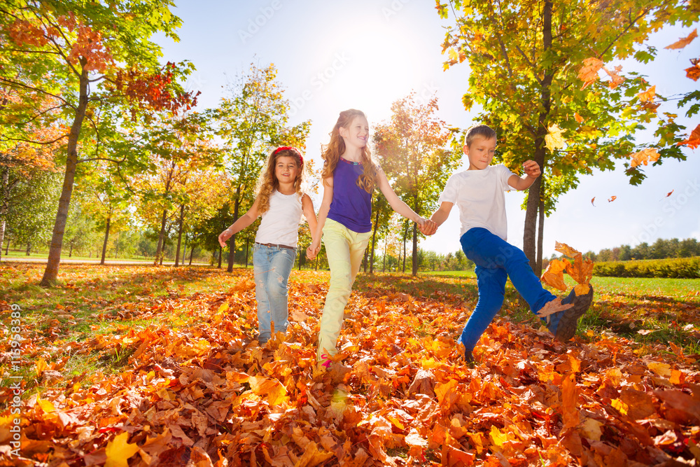 Happy kids play with autumn leaves in the forest Happy kids play with autumn leaves in the forest