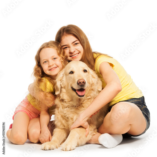 Two happy girls sitting with their pet © Sergey Novikov