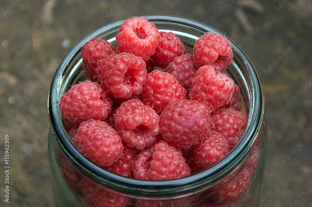 glass jar filled with raspberries glass jar filled with raspberries