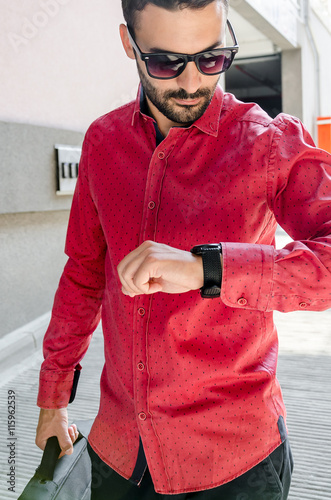 business man in a red shirt looking at his watch photo