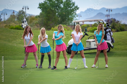 Group of young female golf caddies on golf course.