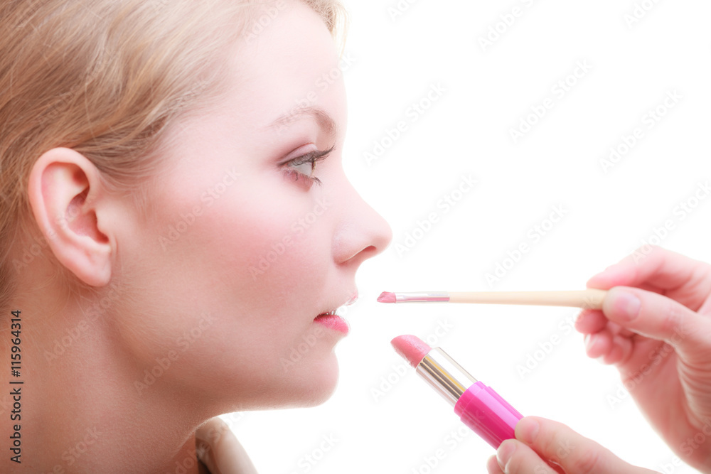 Part of face. Woman applying red lipstick with brush Part of face. Woman applying red lipstick with brush