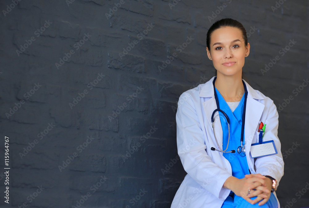 Young woman doctor sitting near wall Young woman doctor sitting near wall