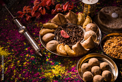 holi festival food with colours, indian festival holi, samosa, kachori, laddu, gujiya, palash flower, thandai, farsan, puran poli or roti, indian festival of colours called holi photo