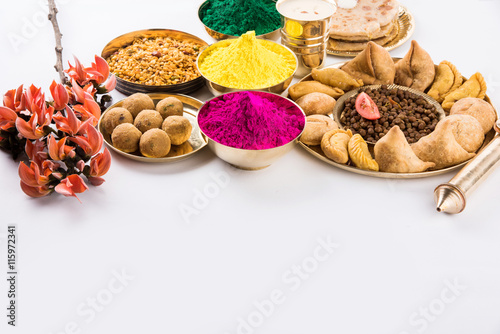 holi festival food with colours, indian festival holi, samosa, kachori, laddu, gujiya, palash flower, thandai, farsan, puran poli or roti, indian festival of colours called holi