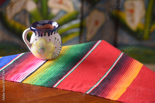 Empty wooden table over wood background with mexican coffee mug copy space