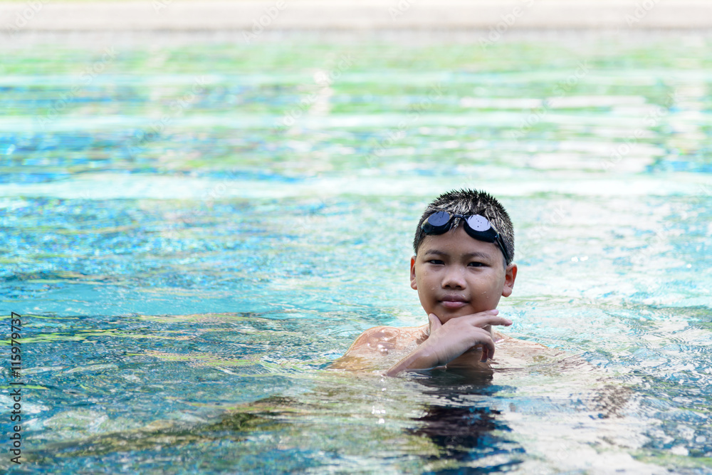 Asian boy swimming in pool on weekend Asian boy swimming in pool on weekend