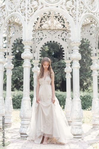 beautiful delicate bride sexy girl in a light beige wedding dress walks in the garden bright sunny warm day