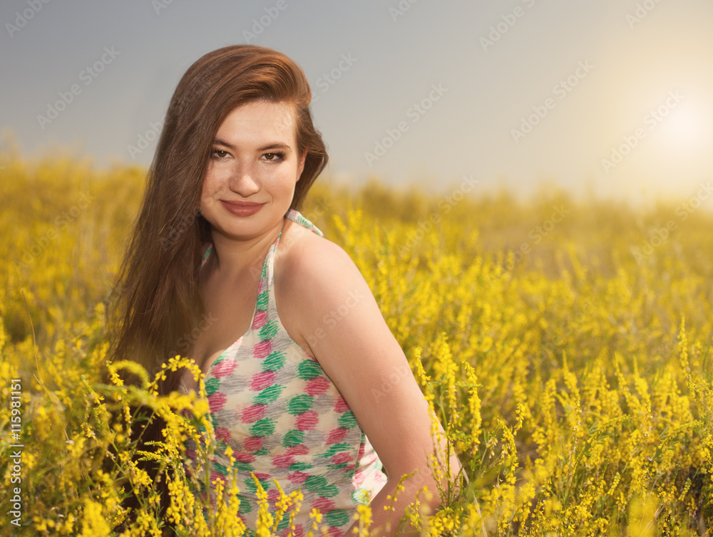 Young beauty woman in the park with yellow flowers Young beauty woman in the park with yellow flowers