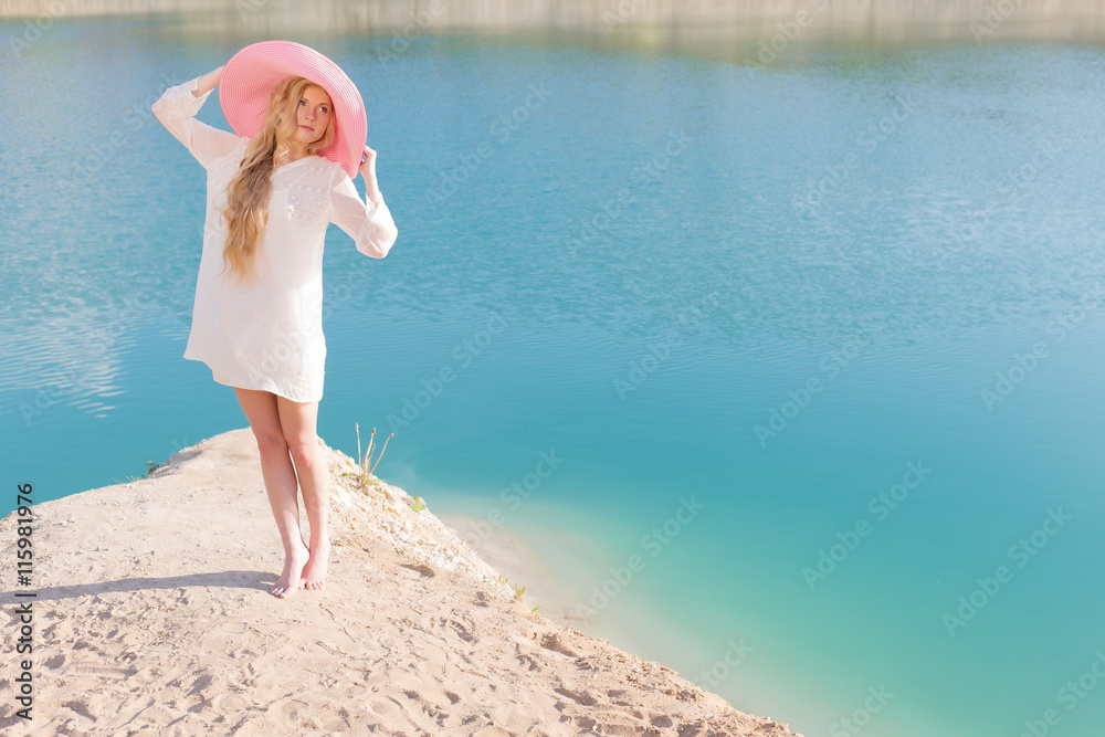 beautiful sweet gentle girl in white dress in light big pink hat on the shore of the blue sea at sunset summer evening sun beautiful sweet gentle girl in white dress in light big pink hat on the shore of the blue sea at sunset summer evening sun