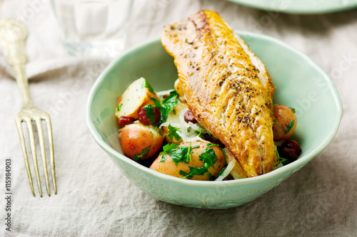 fried mackerel with potatoes in a bowl photo