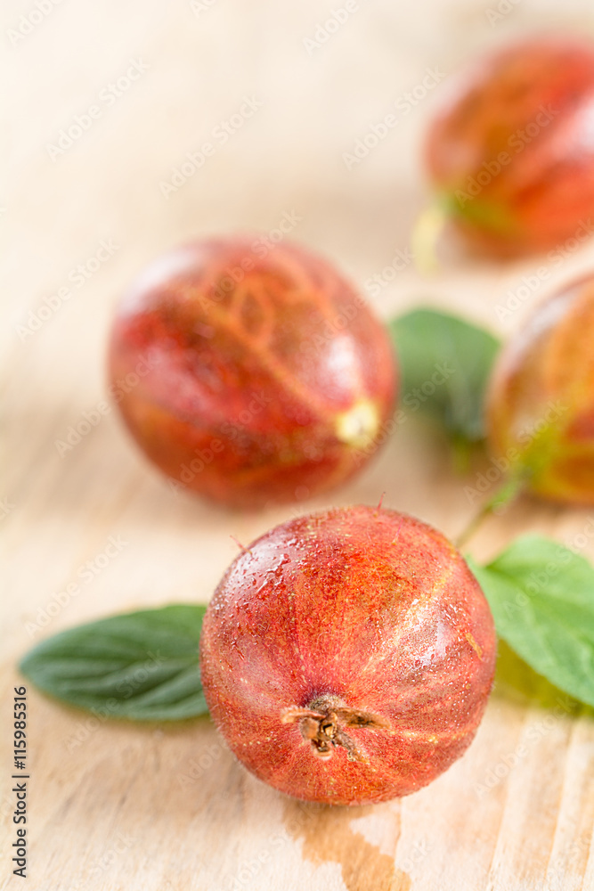 Frische Stachelbeeren liegen auf einem Holztablett Frische Stachelbeeren liegen auf einem Holztablett