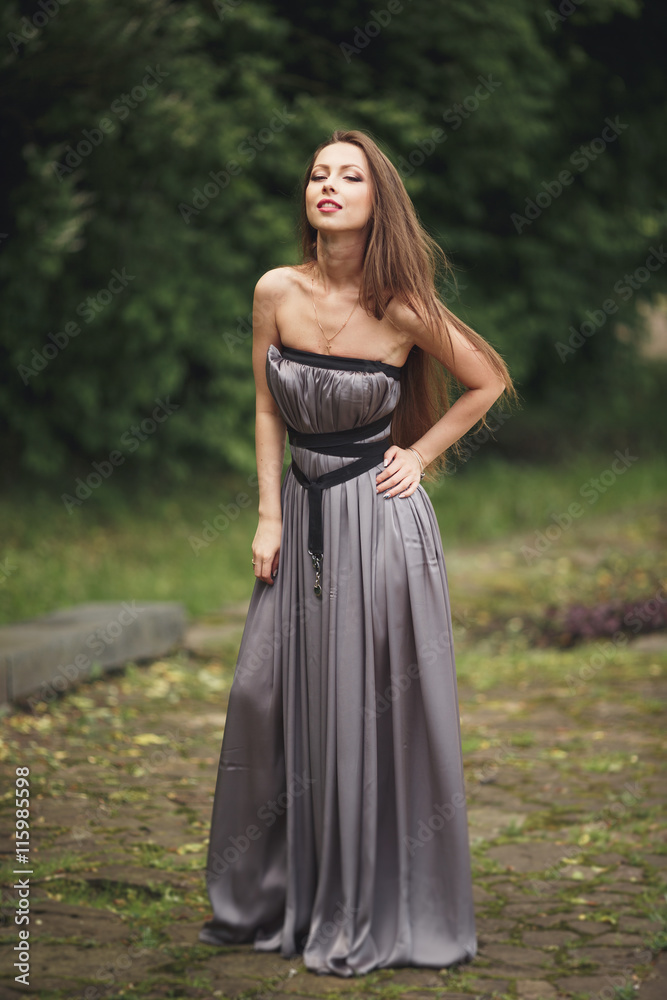 Beauty Romantic Girl Outdoors. Teenage Model with Casual Dress in park. Blowing Long Hair. Beauty Romantic Girl Outdoors. Teenage Model with Casual Dress in park. Blowing Long Hair.