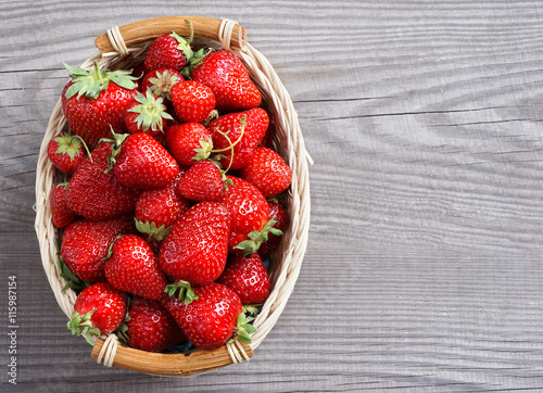 Big strawberry in basket  on wooden background. Close up, top view, high resolution product.